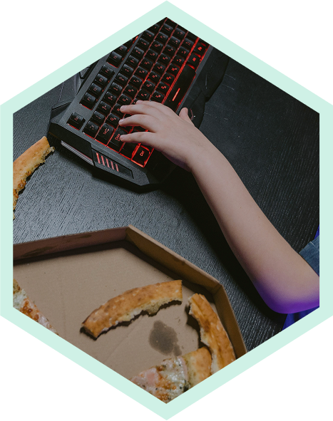 Hand on a gaming keyboard with pizza
